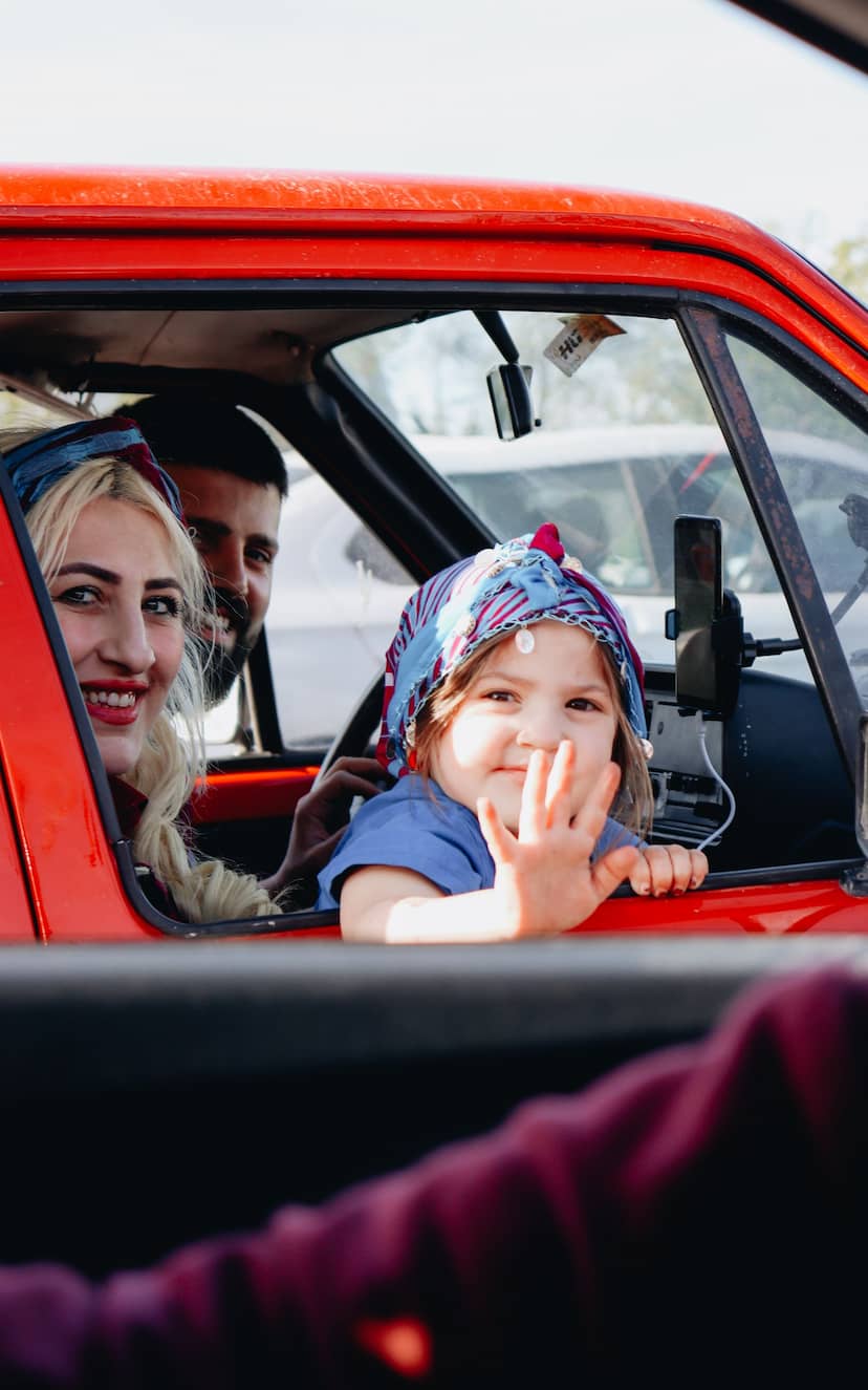 Family waving from their car